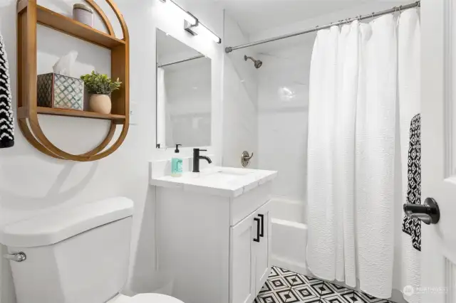 The cutest bathroom with tile shower and tile floor.