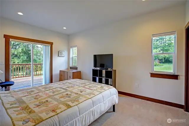 Large guest bedroom with sliding door access to the deck and backyard