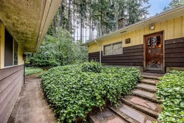 Steps connect garage to rec room door. There is also a paved path at the back of garage that leads to the back of house and yard.