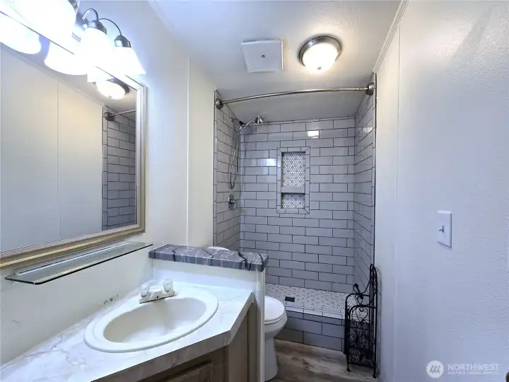 Updated hall bath featuring a beautiful tile shower and modern finishes, adding a touch of everyday luxury.