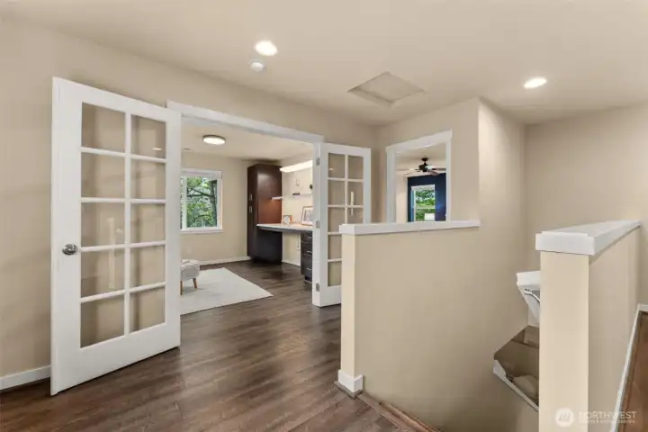 Flexible bonus space featuring a custom desk, upgraded lighting, and elegant French doors