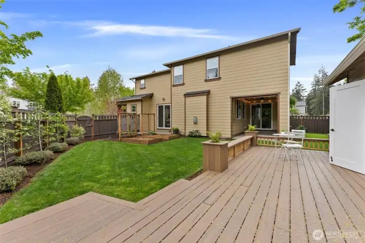 Scenic views from the custom shop deck overlooking garden beds and thoughtfully planted apple trees and grapevines