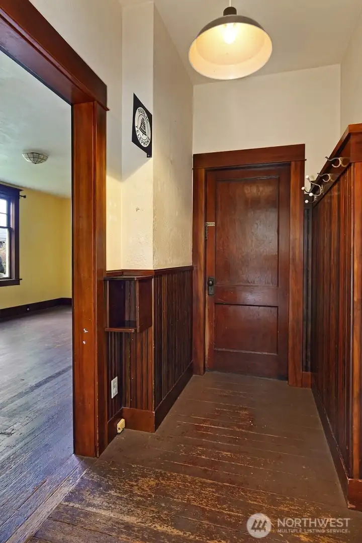 A fun phone box with beautiful wainscoting. Door leads to unfinished basement.