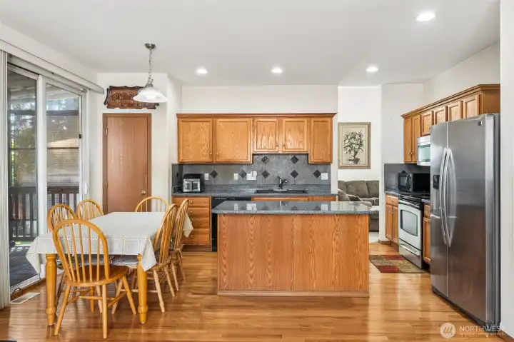 Kitchen featuring an island with seating, opening to the dining nook.