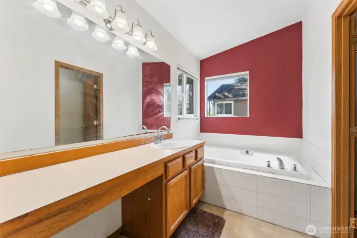 Primary bathroom featuring a soaking tub and separate shower.