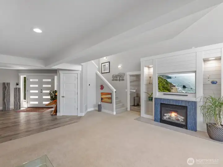 Living room looking back at the main entry. Cozy gas fireplace with custom lighting & cabinets Living room looking back at the main entry. Cozy gas fireplace with custom lighting & cabinets