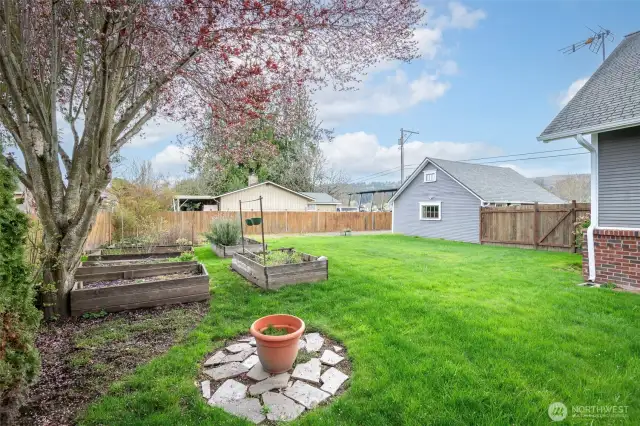 Rear yard with raised planter beds and back of detached garage