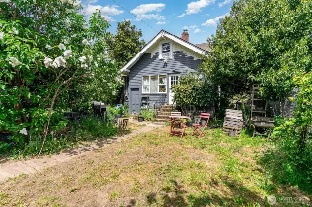 Backyard features mature plants, with room for gardening & entertaining.