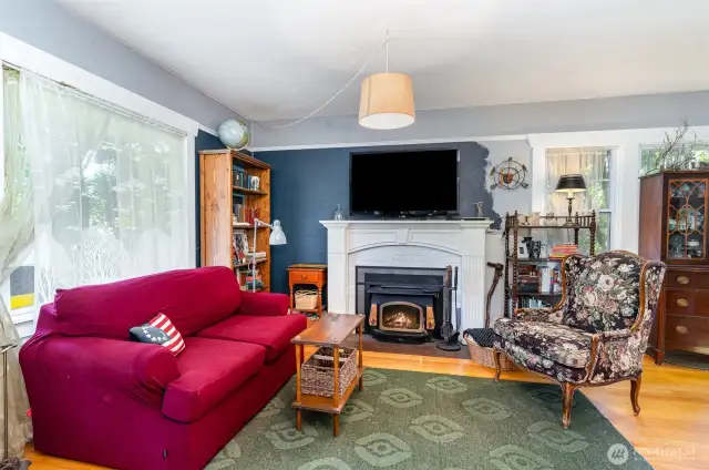 Classic wood-burning fireplace anchors the living room—perfect for staying warm and cozy all year long.