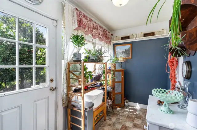 Charming breakfast nook sits beneath a large window, filling the space with natural light—back door offers convenient access to the backyard.