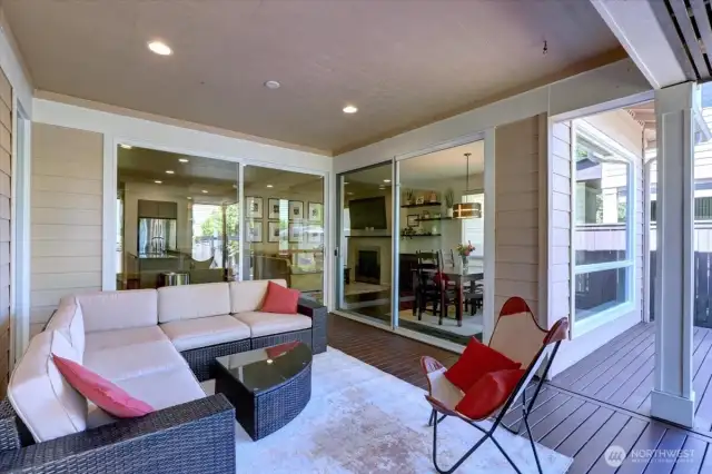 Covered deck with gas fireplace overlooks the beautiful backyard.