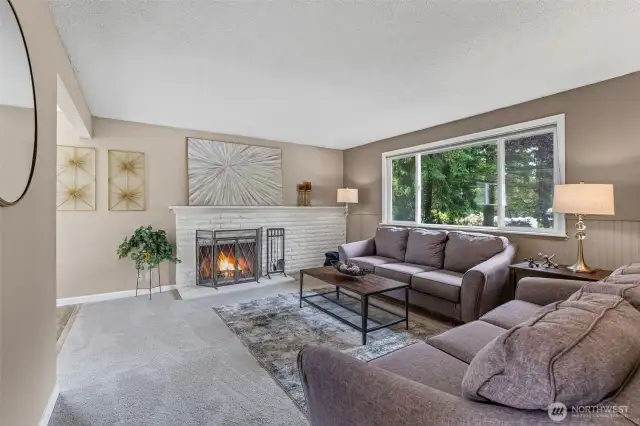 Cozy living room with wood-burning fireplace and new carpet