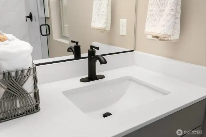 Undermount sinks with quartz counter & upgraded sleek black faucets adds to the elegance.