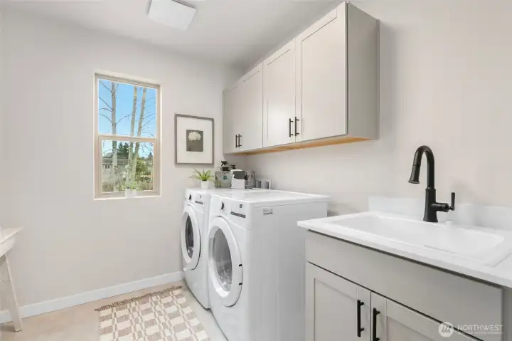 Upstairs laundry room includes deep sink and both upper and lower cabinets for convenience and LG front loading washer & dryer.