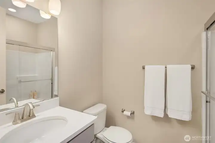 Main floor guest suite's attached bath with oversized shower and storage!