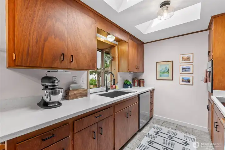Thoughtfully restored original TEAK cabinets complimented by 2025 new quartz counters and extra deep S/S sink.