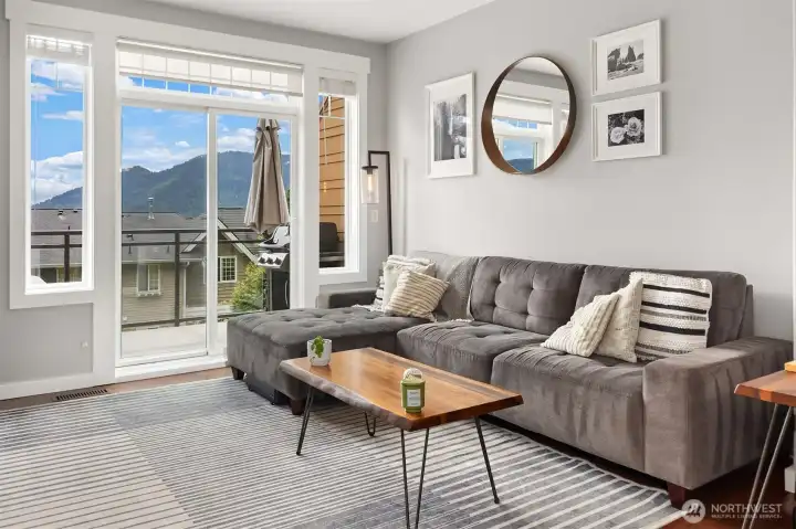 Living room filled with ample natural light and sliding door opening to private deck.