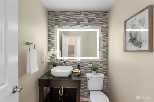 Hall bath with motion sensor lighting and custom tiled wall.