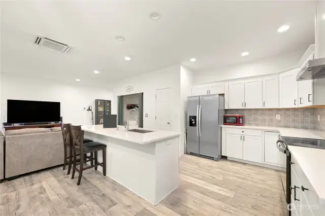 Kitchen boasts quartz countertops and large island