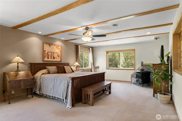 Spacious primary suite on the floor with pellet stove in the corner.
