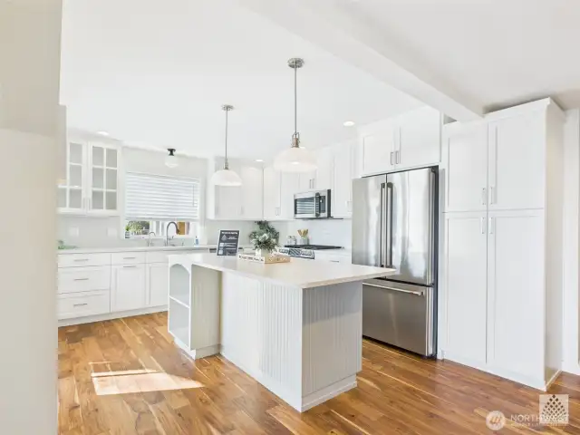 This updated, light-filled kitchen features stainless steel appliances, a spacious island with bar seating - perfect for gathering. In addition it boasts a large custom pantry with convenient pull-out shelves