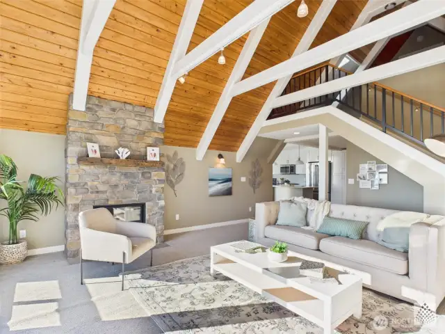 The cozy family room connects to the upstairs loft and third bedroom via a custom iron railing, blending comfort with unique architectural detail.