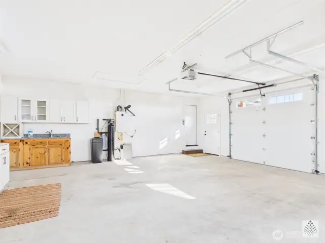 The spacious two-car garage also features a second dedicated workspace with upper and lower cabinet and a fully function sink - perfect for projects, hobbies and extra storage.
