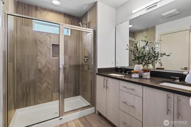 Primary bath boasts oversized shower plus dual vanities with quartz counters and undermount sinks