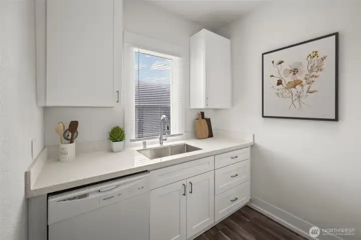 Unit B kitchen with new shaker cabinets, quartz countertops, dishwasher and fixtures.