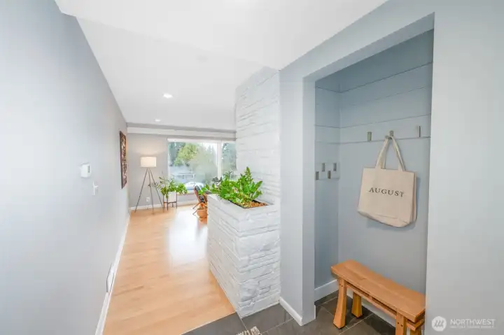 Main floor is full of light, newer hardwood floors and MCM architectural details like the brick built-in planter.