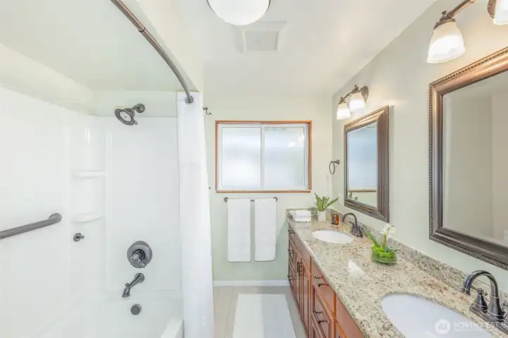 Main floor full bathroom, double vanity and granite countertops.