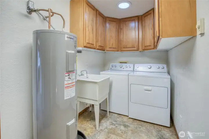 From the kitchen is the laundry room with surrounding cabinetry, designated main floor hot water tank and soaking tub! From the kitchen is the laundry room with surrounding cabinetry, designated main floor hot water tank and soaking tub!