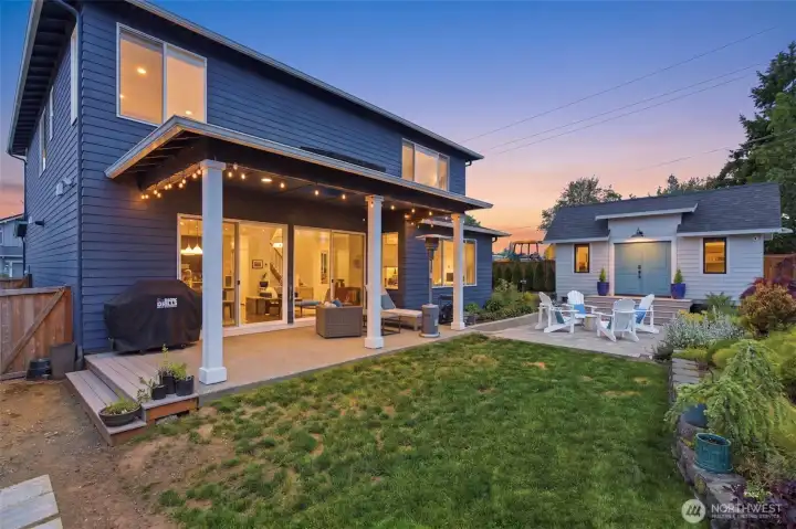 Covered patio and back yard with lawn and landscaping