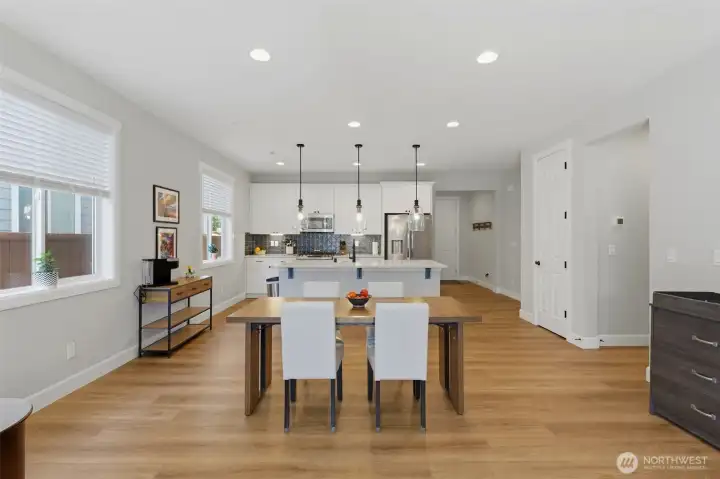 Open-concept dining at its finest. Enjoy a dedicated space for your dining table right off the kitchen, flooded with natural light from the nearby wall of windows.