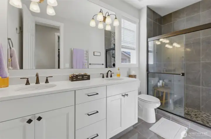 Bright, pristine, and modern. The primary bath combines stylish finishes with a functional layout to make your morning routine an absolute breeze.