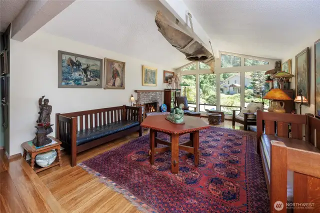 Natural light filled living room with vaulted ceilings, picture windows, bamboo floors and wood burning fireplace.
