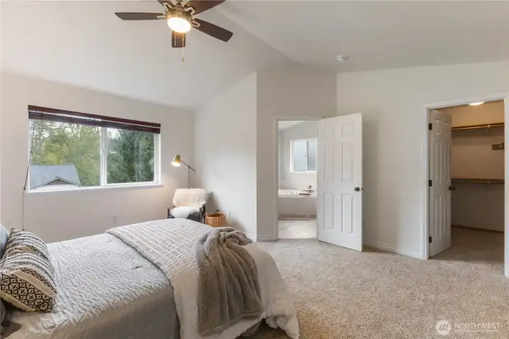 The primary bedroom has vaulted ceilings, an en suite bathroom, and a walk-in closet.