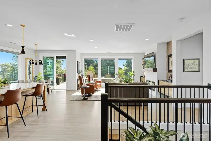 Kitchen with eating space at the island and at the dinner table combines with the great room and fireplace.  Access to the upper level deck is through the sliding doors.  Access to walk out first floor is down the stairs.