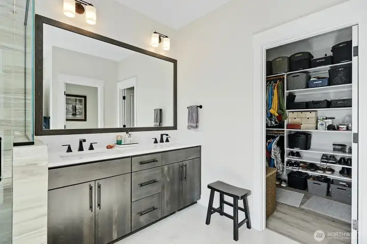 Double sinks and large mirror in the primary bathroom along with a walk-in closet.