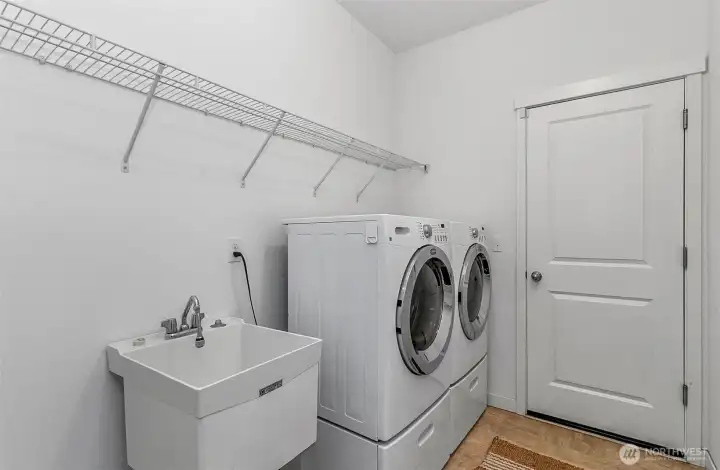 Large utility room with sink, washer/dryer and a great amount of storage space