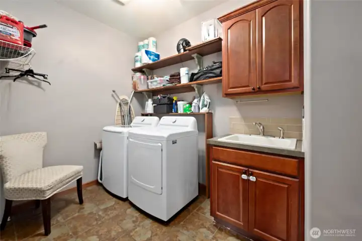 Tiled in laundry room with utility sink and plenty of storage. Tiled in laundry room with utility sink and plenty of storage.