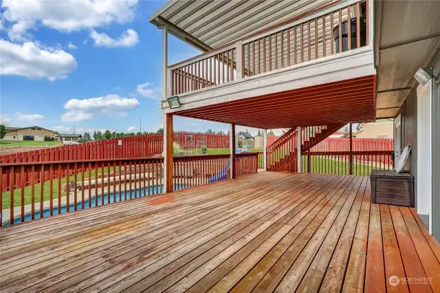 A lovely view of the two decks and the stairway leading down to both decks and the pool