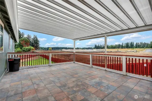 Through the french doors off the kitchen you have access to this enormous covered deck. The flooring of the deck is made of intricate tiles.