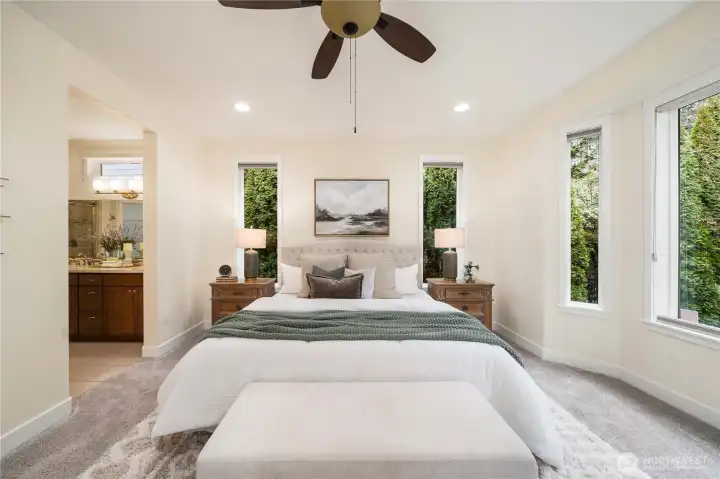 Primary bedroom offers serenity and privacy due to the mature trees and overlooks greenspace.  Custom window coverings and a ceiling fan.