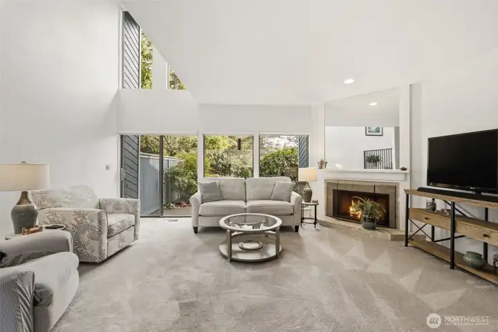 Light and bright main living area, with vaulted ceilings. Wood burning fireplace for cozy nights. View into private backyard and patio.