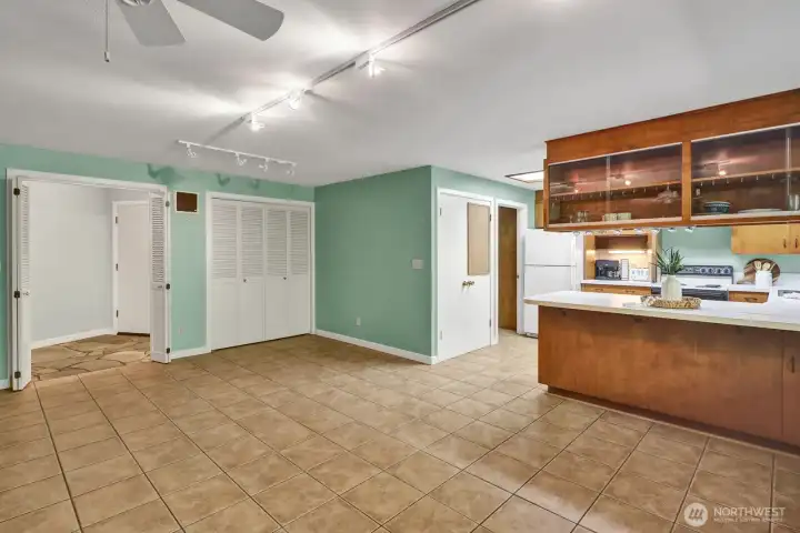 Kitchen and dining room with the front door entry to the left, and doors are a pantry, and to the right is the laundry room and the half bath, built in cabinetry for plentry of storage, and door to the garage.