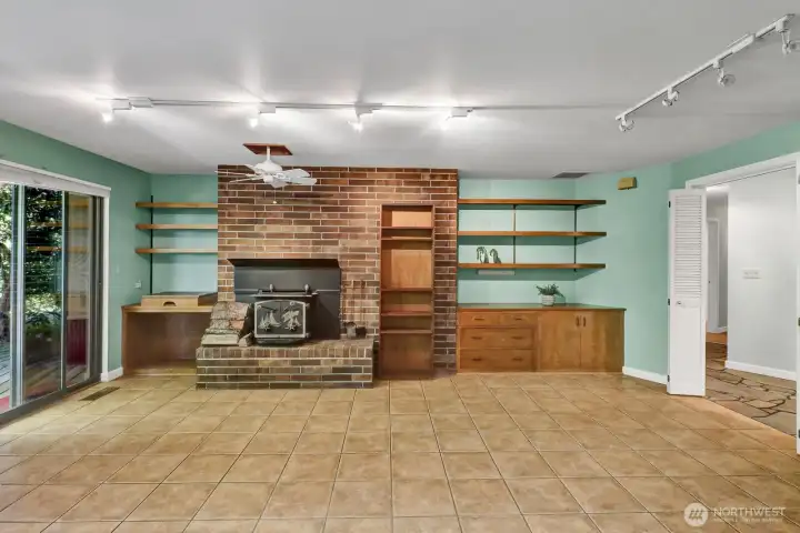 Spacious family room with ceiling fan to help with the heat generated from the wood stove insert.