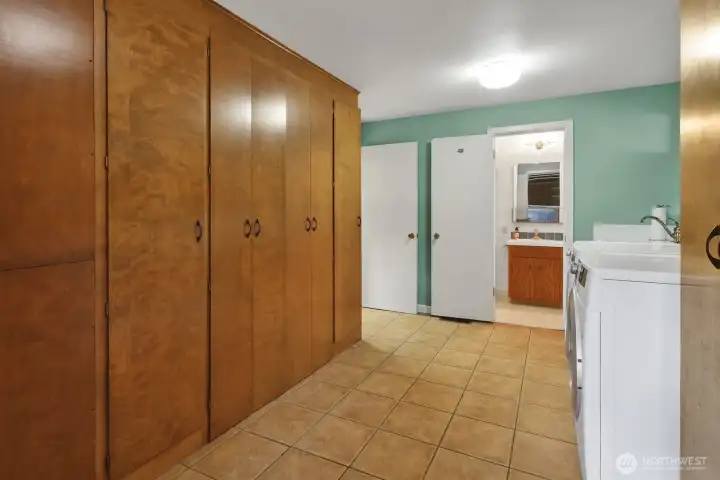 Laundry room with a wall of built in cabinets, tile flooring, and 3/4 Bath. Washer & Dryer included.