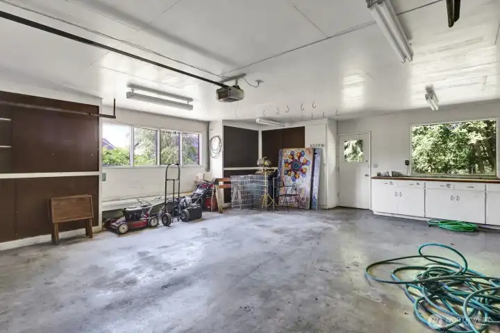 Garage with work benches and utility room. Door to the back yard.