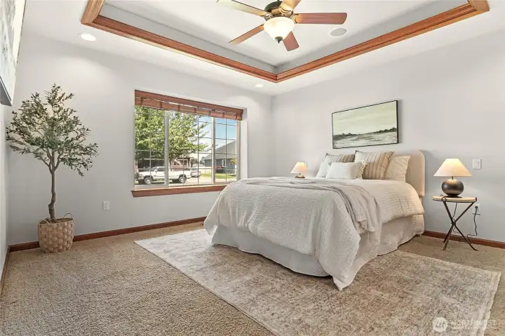 Owner's suite on the main floor near front entry with custom tray ceiling, fan, built-in speakers, ensuite bathroom, walk-in closet Owner's suite on the main floor near front entry with custom tray ceiling, fan, built-in speakers, ensuite bathroom, walk-in closet